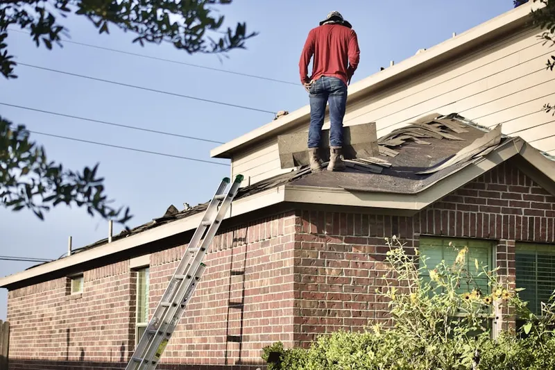 Professional roofer working on a residential roof in Vinita